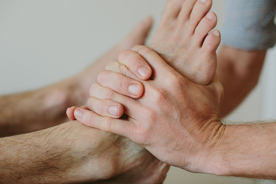 Osteopath treating a patient's rolled ankle (sports injury).